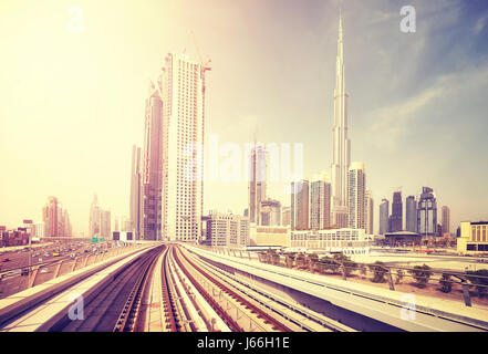 Dubai modern downtown seen from metro train, color toning applied, United Arab Emirates. Stock Photo