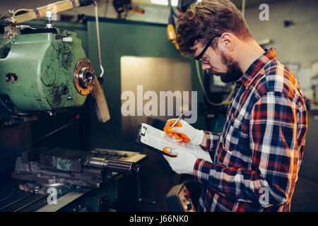Young mechanic checks list Stock Photo
