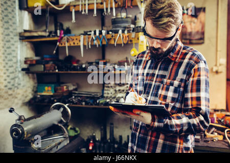 Young mechanic checks list Stock Photo