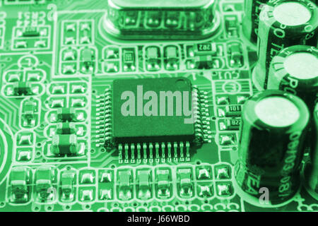 Chip on motherboard mainboard with controllers, ports and wires, close-up macro toned. Stock Photo