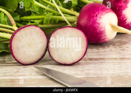 Juicy fresh radish in a cut on a white wooden background close up Stock Photo