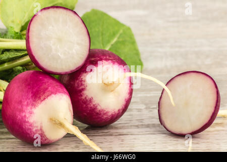 Juicy fresh radish in a cut on a white wooden background close up Stock Photo
