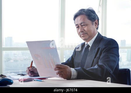 senior working man reading business paper report on working table use for people in office life Stock Photo