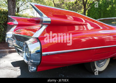 Detail photograph of the tail fins on a vintage red Cadillac convertible, circa 1950's in a car park in Napa county California.