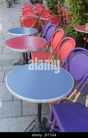 Colored tables and chairs on a sidewalk cafe in Paris -France Stock Photo