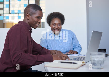 African business entrepeneurs working on a laptop in a white office Stock Photo