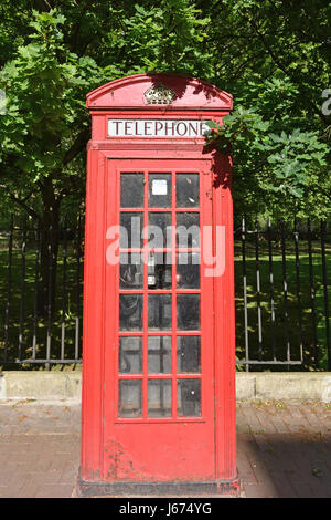 Old Red British Telephone Box on a sidewalk by Battersea Park. Stock Photo