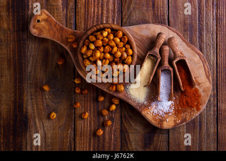 Roasted spicy chickpeas with salt, garlic and paprica on rustic background Stock Photo