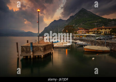Marone harbour on Iseo Lake with mountains in storm in background, Italy Stock Photo