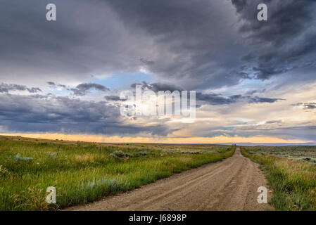 Road and sunset clouds on the sagebrush plateau between Red Lodge and Luther, Montana. Stock Photo