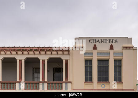Napier, New Zealand - March 9, 2017: Part of Art Deco Facade of hotel in Emerson shopping street against silver sky. The word Chambers is painted big 