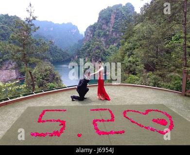 Zhangjiajie, China's Hunan Province. 20th May, 2017. A couple pose for photos at the Baofeng Lake scenic area of Zhangjiajie, central China's Hunan Province, May 20, 2017. Many couples in China chose to register for marriage or get married on May 20 as the pronunciation of '520' is homophonic for 'I Love You' in Chinese. Credit: Wu Yongbing/Xinhua/Alamy Live News Stock Photo