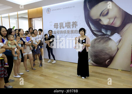 (170520) -- BEIJING, May 20, 2017 (Xinhua) -- Song Dan (1st R) takes part in an event to promote breastfeeding at a department store in Beijing, capital of China, Aug. 6, 2016.  Song Dan, a former IT engineer working for renowned Chinese IT firm Huawei, is now a senior lactagogue master, a profession to help new mothers to stimulate the secretion of milk through massage.  Song started her brand new business five years ago when she had to face a choice between her IT engineer carrier and family. The advantage of flexible working time as lactagogue master made Song determine to give up her forme Stock Photo