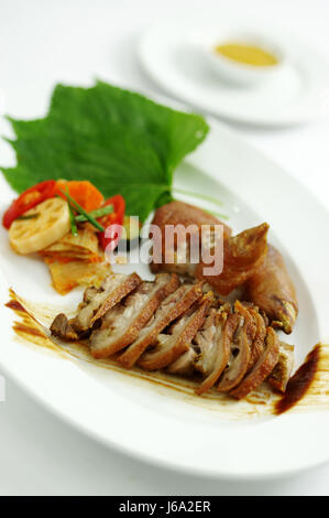 Grilled pig's legs with lotus and kimchi on white platter Stock Photo