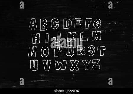 Hand drawn abc, doodle style. White letters over black chalkboard background, sketch illustration Stock Photo