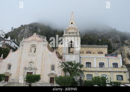 Nice church in Taormina, Sicily island, Italy.On a square, interesting design and facade. Misty weather, in fof, hill on backgrounds Stock Photo