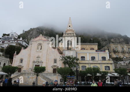 Nice church in Taormina, Sicily island, Italy.On a square, interesting design and facade. Misty weather, in fof, hill on backgrounds Stock Photo