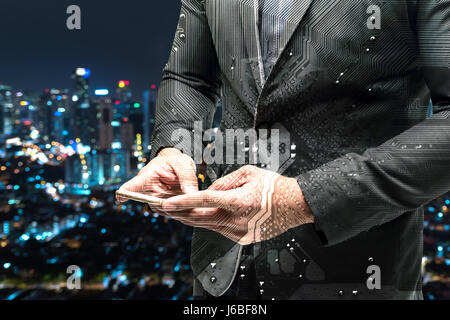 Double exposure of Electric circuit graphic and Business man suit using smart phone with blur bokeh city background. Chatbot , Smart city and internet Stock Photo