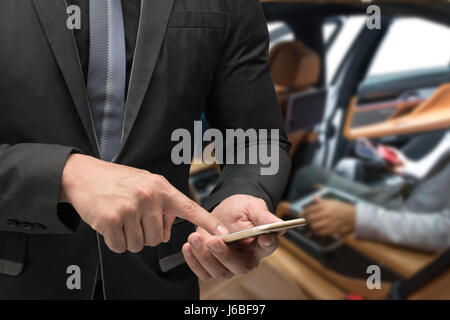 Chatbot future marketing and car sharing concept. Business man suit using smart phone with blur inside car background. Stock Photo