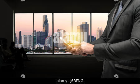 Business man suit using smart phone and flare light with window metropolis city background. Chatbot , Smart city and internet of things concept. Stock Photo