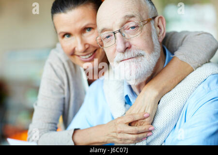 Devoted senior spouses looking at camera Stock Photo