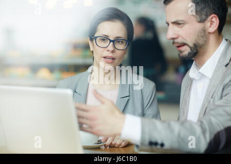 Group of economists discussing online data at meeting Stock Photo
