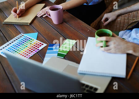 Closeup shot of designers working in modern web studio choosing color scheme for project Stock Photo