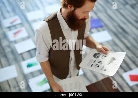 Portrait of young creative designer  working on color concept and scheme choosing colors for project  on floor Stock Photo