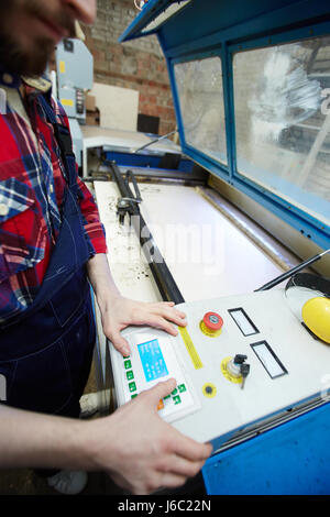 Portrait of unrecognizable worker operating machines in factory workshop Stock Photo