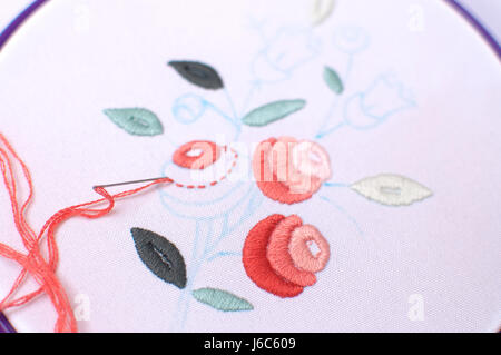 Embroidery with floral motif framed in a hoop. Work in process. Close up, soft selective focus. Stock Photo