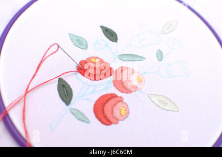 Embroidery with floral motif framed in a hoop. Work in process. Close up, soft selective focus. Stock Photo