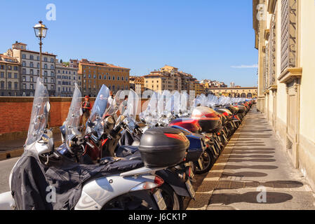 Parking mopeds on Lungarno Generale Diaz, an embankment along the Arno river - Florence, Tuscany, Italy Stock Photo