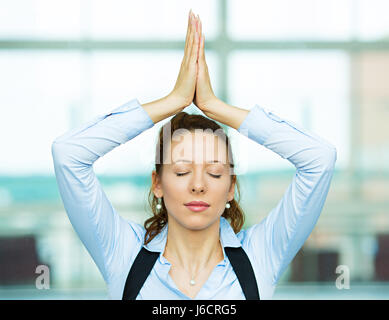 Closeup portrait beautiful hispanic businesswoman relaxing meditating eyes closed, indoors corporate building, office by doing some yoga isolated back Stock Photo
