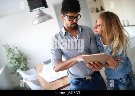 Young couple smiling and happily shopping on tablet Stock Photo