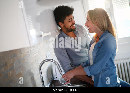 Young couple in love doing dishes in the kitchen and smiling Stock Photo