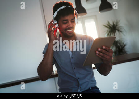 Handsome african american man listening to music on tablet Stock Photo