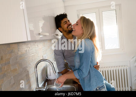 Young couple in love doing dishes in the kitchen and smiling Stock Photo