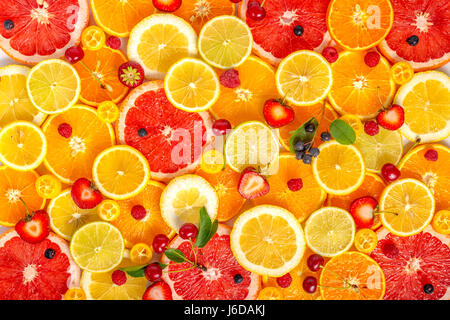 top view of  beautiful fresh trendy seamless pattern sliced mixed citrus fruits as background with different berries, concept of healthy eating, dieti Stock Photo