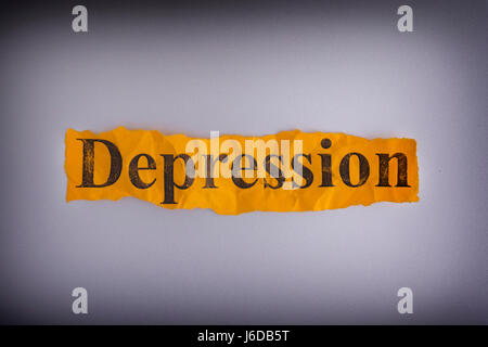 Torn crumpled piece of yellow paper with the word Depression. Concept image. Stock Photo