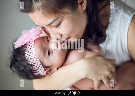 A beautiful asian mother holding her newborn baby Stock Photo