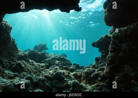 Underwater sunlight through water surface from a hole in a rocky ocean floor, natural scene, Pacific ocean, outer reef of Huahine, French Polynesia Stock Photo