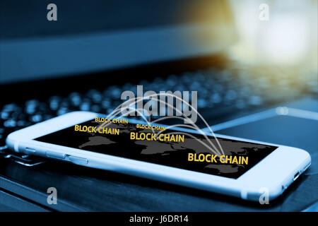 Digital money , blockchain and bitcoin concept. Block chain texts and network connect link and smartphone screen with blur laptop background , flare l Stock Photo