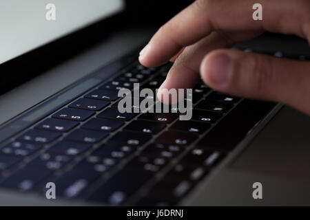 close-up finger typing on keyboard computer working at night Stock Photo