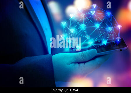 Internet of things (IOT) concept . Business woman hand holding tablet with Wifi connect icons with bokeh abstract background. blue tone image Stock Photo