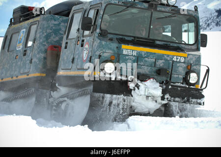 An M973A1 Small Unit Support Vehicle , aka SUSV, clad in emergency lights and digital camouflage, claws its way through the snow at Taylor Park Reservoir near Gunnison, Colo., March 15, 2010. The SUSV, which is capable of traversing almost any terrain, is the primary vehicle used by the Colorado Army National Guard’s Snow Response Team. This relatively unknown asset can be used by the SRT to assist state and local rescue teams during nearly every type of disaster, state emergency or search and rescue. (U.S. Army National Guard photo by Spc. Joseph K. VonNida, Colorado National Guard) Stock Photo