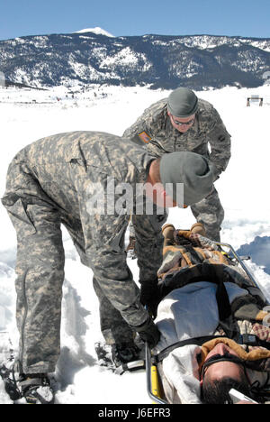 Members of the Colorado Army National Guard’s Snow Response Team load a patient into an M973A1 Small Unit Support Vehicle, aka SUSV, during a training exercise at Taylor Park Reservoir near Gunnison, Colo., March 15, 2010. The SRT is a relatively unknown asset available to support state and local emergency response teams during blizzards and other disasters. (U.S. Army National Guard photo by Spc. Joseph K. VonNida, Colorado National Guard) Stock Photo