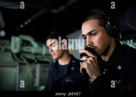 WATERS OUTSIDE OF OKINAWA (Aug. 12, 2016) Quartermaster 3rd Class Anthony Gonzalez, from Hartford, Conn., uses a sound powered telephone aboard the amphibious transport dock ship USS Green Bay (LPD 20). Green Bay, part of the Bonhomme Richard Expeditionary Strike Group, is operating in the U.S. 7th Fleet area of operations in support of security and stability in the Indo-Asia-Pacific region. (U.S. Navy photo by Mass Communication Specialist 1st Class Chris Williamson/Released) Stock Photo