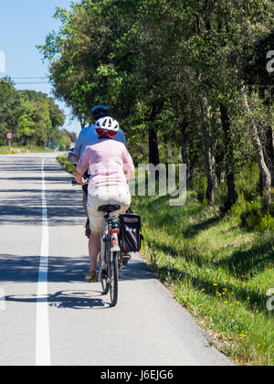 Two touring cyclists riding their bicycles in the countryside of Province of Girona, Spain. Stock Photo