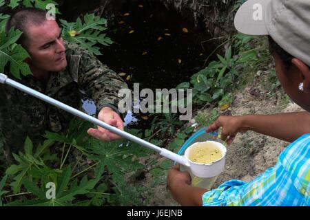 160817-A-CP070-0517 CHOLOMA, Honduras (Aug. 17, 2016) U.S. Navy Hospital Corpsman 1st Class Michael Bigelow, a preventive medicine technician assigned to Naval Environmental Preventive Medicine Unit 2, gives a water sample to Xenia Caballero, a member of Operation Blessing, during Southern Partnership Station 2016 (SPS-16). SPS-16 is an annual series of U.S. Navy deployments focused on subject matter expert exchanges with partner nation militaries and security forces in Central and South America and the Caribbean. U.S. military teams work with partner nation forces during naval-focused trainin Stock Photo