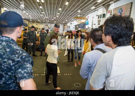 160820-N-XK809-200 OKINAWA, Japan (Aug. 20, 2016) Lt. John Kadz guides officers of the Japanese Maritime Self Defense Force (JMSDF) and members of the local community on a tour of the hangar bay aboard amphibious assault ship USS Bonhomme Richard (LHD 6). The tour provided community members an opportunity to see Bonhomme Richard and learn about the U.S. Navy. Bonhomme Richard, flagship of the Bonhomme Richard Expeditionary Strike Group, is operating in the U.S. 7th Fleet area of operations in support of security and stability in the Indo-Asia- Pacific region. (U.S. Navy photo by Mass Communica Stock Photo